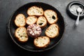 Fresh crispy crostini baguette slices with baked garlic, butter and cheese in a baking dish on a dark background. Top