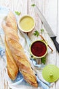Fresh crispy French baguette with chicken liver pate and berry marmalade on a white aged background.