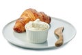 Fresh croissant and bowl of cream cheese on plate over white background Royalty Free Stock Photo