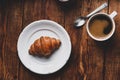 Fresh Croissant and Cup of Coffee on Wooden Surface Royalty Free Stock Photo