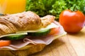 Fresh croissant with ham, cheese and salad