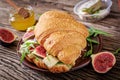 Fresh croissant sandwich with brie cheese arugula and figs.