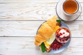 Fresh croissant sandwich, homemade yogurt, pomegranate and tea