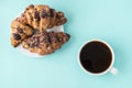 Fresh croissant and white cup of coffee on the light blue background. Place for text, copy space. Flat lay Royalty Free Stock Photo