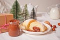 Fresh croissants bun with chocolate on the plate, cup of coffee, jar of milk nearby, three little Christmas tree toy and gift box Royalty Free Stock Photo