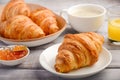 Fresh Croissants with coffee, jam and orange juice for breakfast on rustic wooden background. Royalty Free Stock Photo