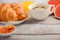Fresh Croissants with coffee, jam and orange juice for breakfast on rustic wooden background. Royalty Free Stock Photo