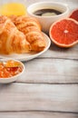 Fresh Croissants with coffee, jam and orange juice for breakfast on rustic wooden background Royalty Free Stock Photo