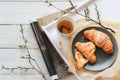 Fresh croissants and a cup of tea for the breakfast. Bright mood flatlay