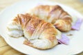 Fresh croissants with ham and cheese on plate