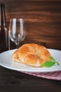 Fresh croissants placed on a plate with props and flowers as props, French breakfast