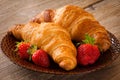 Fresh croissants with strawberries on plate, breakfast food, warm tone Royalty Free Stock Photo