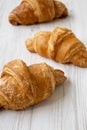 Fresh croissants on a white wooden surface, low angle view. Close-up. Selective focus Royalty Free Stock Photo