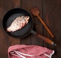 Fresh crucian fish sprinkled with spices and lies in a black round pan