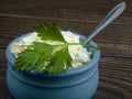 Fresh crumbly cottage cheese close-up on a dark table against the background of white eggs in a tray