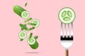 Fresh cucumber on fork with flying cucumbers background , healthy food concept