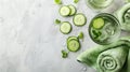 Fresh cucumber slices and mint leaves are elegantly arranged next to a glass of infused water, evoking a sense of refreshment and Royalty Free Stock Photo