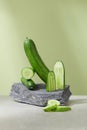 Fresh cucumbers are artistically arranged on a stone slab on a white-light green background. Cucumbers are low in calories but