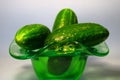 Fresh cucumbers in a green vase on the table.