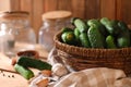 Fresh cucumbers and other ingredients near empty jars prepared for canning on wooden table, closeup Royalty Free Stock Photo