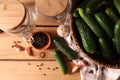 Fresh cucumbers and other ingredients near jars prepared for canning on wooden table, flat lay Royalty Free Stock Photo