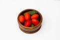 Fresh cucumbers and tomatoes in a wooden bowl on the white wooden table Royalty Free Stock Photo