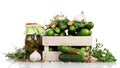 Fresh cucumbers in wooden box and jar pickled spices isolated.