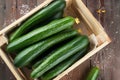 Fresh cucumbers in wooden crate.