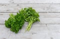 fresh, curly and flat parsley on a light wooden background