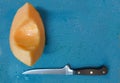 Fresh cut Cantaloupe wedge on blue background with knife