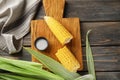 Fresh cut corn cob and bowl with salt on wooden board Royalty Free Stock Photo