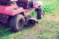 Fresh cut grass flying from riding lawnmower person cutting long