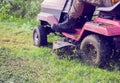 Fresh cut grass flying from riding lawnmower person cutting long