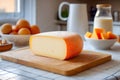 A fresh cut of Mahon cheese displayed elegantly in a modern, sunlit kitchen