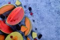 Fresh cut melons, watermelon and berries on a blue stone background Royalty Free Stock Photo