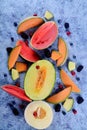 Fresh cut melons, watermelon and berries on a blue stone background Royalty Free Stock Photo