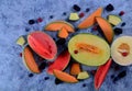 Fresh cut melons, watermelon and berries on a blue stone background Royalty Free Stock Photo