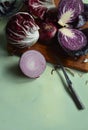 Fresh cut red cabbage on cutting board, red onion, red radicchio