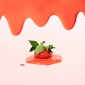 Fresh cut strawberry in a red melting cream on pink background