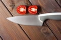Fresh cut tomatoes with knife on the dark wooden table Royalty Free Stock Photo