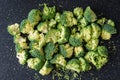 Fresh cut up florets of broccoli ready for cooking, large black cutting board Royalty Free Stock Photo