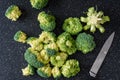 Fresh cut up florets of broccoli ready for cooking, large black cutting board, paring knife Royalty Free Stock Photo