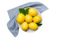 Fresh cutted lemon and whole lemons over round plate isolated on white background. Food and drink ingredients preparing Royalty Free Stock Photo