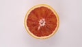 fresh cutted red orange spinning on white background top down view. Freshly picked sour or sweet cut fruit on turntable Royalty Free Stock Photo