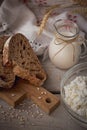 Fresh dairy products. Milk, cottage cheese, sour cream, multigrain homemade bread and wheat on rustic wooden background. Royalty Free Stock Photo