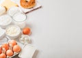 Fresh dairy products on white table background. Glass of milk, bowl of sour cream and cottage cheese and eggs. Fresh baked bagel.