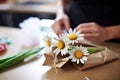 fresh daisies being wrapped in brown craft paper
