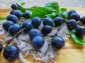 Fresh, dark blue plums scattered on the table Royalty Free Stock Photo