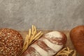 Fresh dark bread with spikelet of wheat on grey concrete table Royalty Free Stock Photo