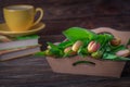 Fresh delicate red yellow flowers tulips, books and yellow cup on a brown wooden background Royalty Free Stock Photo